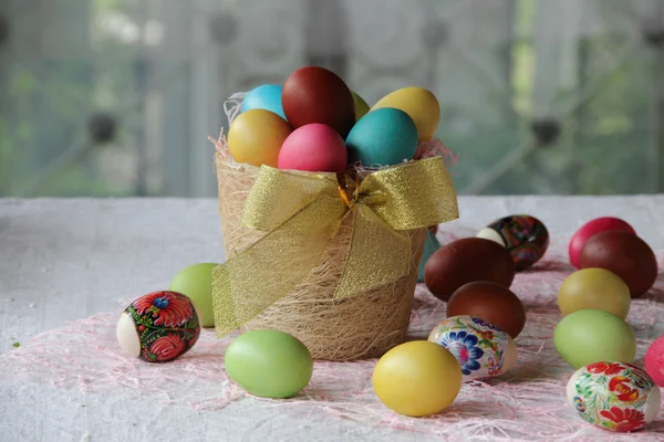 Πασχαλινά αυγά στο καλάθι και στο τραπέζι — Φωτογραφία Αρχείου