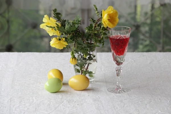 Натюрморт с вином, пасхальные яйца и букет роз — стоковое фото
