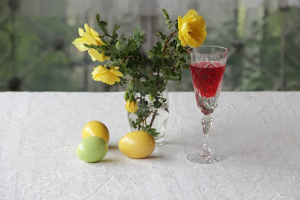 Натюрморт с вином, пасхальные яйца и букет роз — стоковое фото