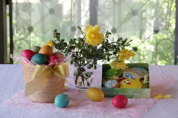 Galletas de Pascua en una caja y huevos de Pascua en una cesta — Foto de Stock