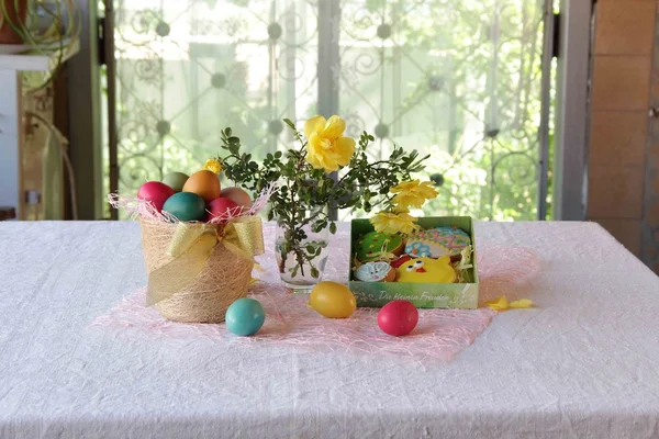 Пасхальное печенье в коробке и пасхальные яйца в корзине — стоковое фото