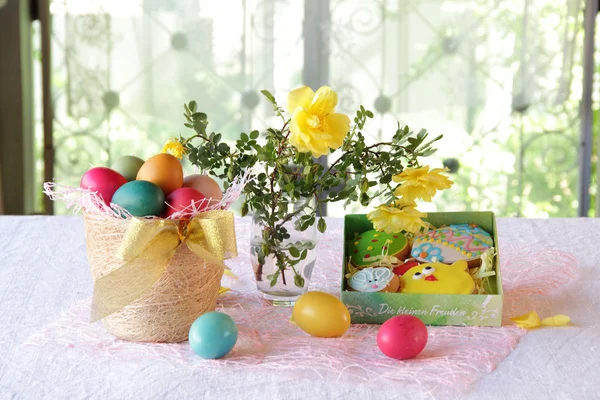 Galletas de Pascua en una caja y huevos de Pascua en una cesta — Foto de Stock