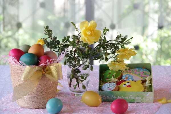 Galletas de Pascua en una caja y huevos de Pascua en una cesta — Foto de Stock