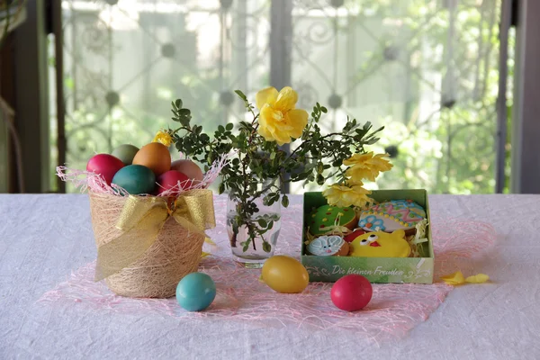 Biscuits de Pâques dans une boîte et œufs de Pâques dans un panier — Photo