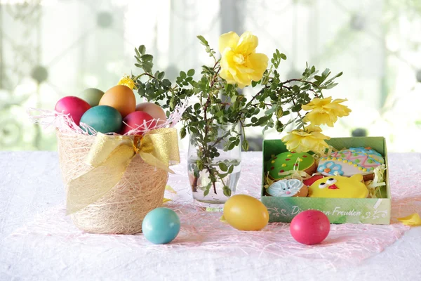 Galletas de Pascua en una caja y huevos de Pascua en una cesta — Foto de Stock