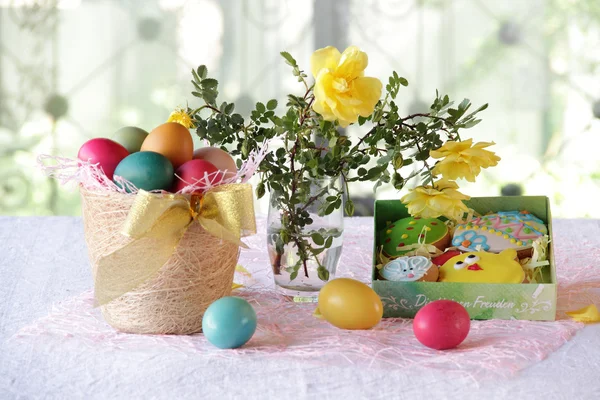 Пасхальный натюрморт с окрашенными яйцами и пасхальными печеньями — стоковое фото