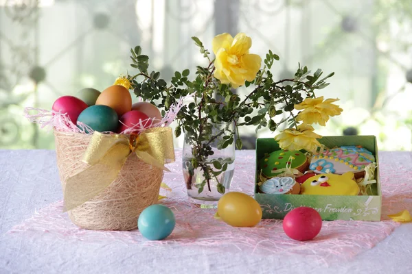 Пасхальный натюрморт с окрашенными яйцами и пасхальными печеньями — стоковое фото
