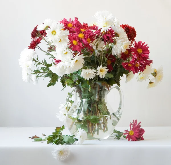 Strauß Chrysanthemen in einem transparenten Glas auf weißem Hintergrund — Stockfoto