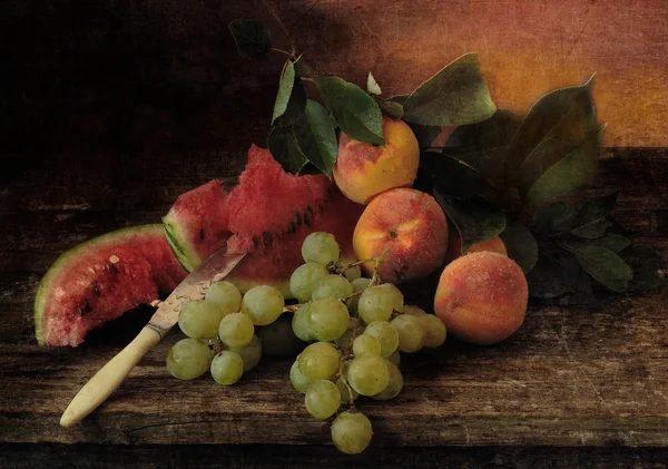 Натюрморт с персиками, виноградом и спелыми арбузами — стоковое фото