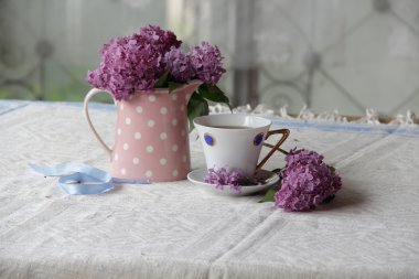 bir fincan çay ve leylak buket