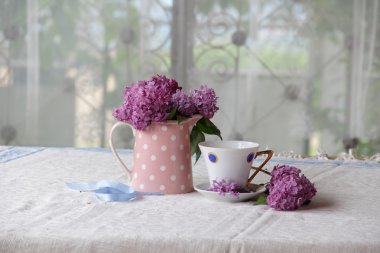 bir fincan çay ve leylak buket