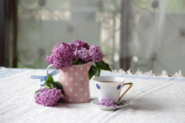 한 잔의 차와 라일락의 꽃다발에 — 스톡 사진