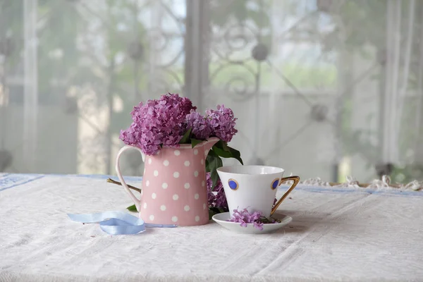 Buquê de lilás e xícara de chá na mesa — Fotografia de Stock