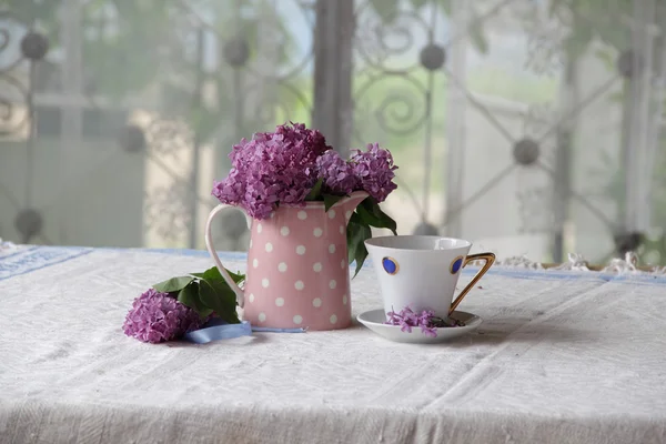 Bukiet bzu i tea Cup na stole — Zdjęcie stockowe