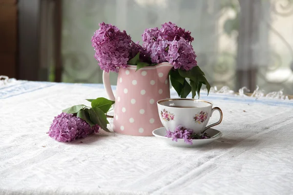 Bouquet de lilas et thé Coupe sur la table — Photo