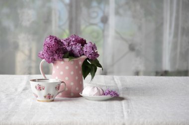 bir fincan çay ve şekerleme ve leylak sekmesinde bir buket