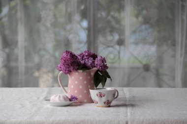 bir fincan çay ve şekerleme ve leylak sekmesinde bir buket