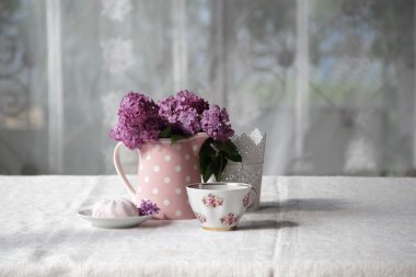 bir fincan çay ve şekerleme ve leylak sekmesinde bir buket