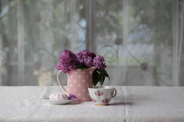 Чашка чая, зефир и букет сирени на закладке — стоковое фото
