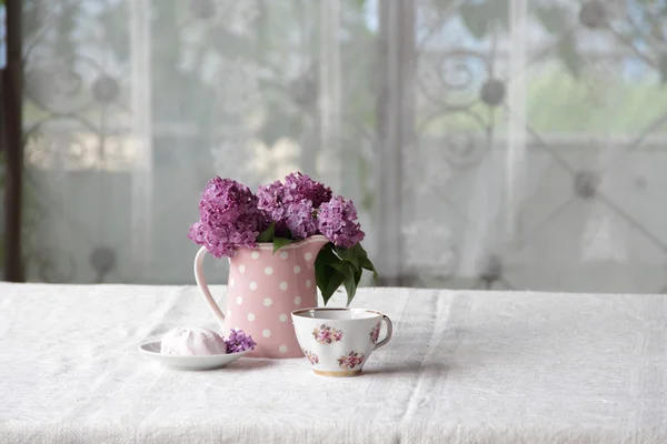 Na filiżankę herbaty i marshmallows i bukiet bzu na karcie — Zdjęcie stockowe