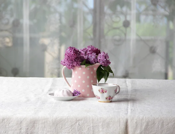 Na filiżankę herbaty i marshmallows i bukiet bzu na karcie — Zdjęcie stockowe