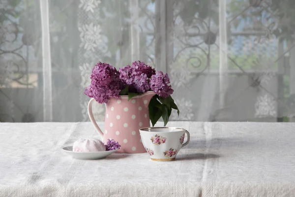Eine Tasse Tee und Marshmallows und ein Strauß Flieder auf der Lasche — Stockfoto