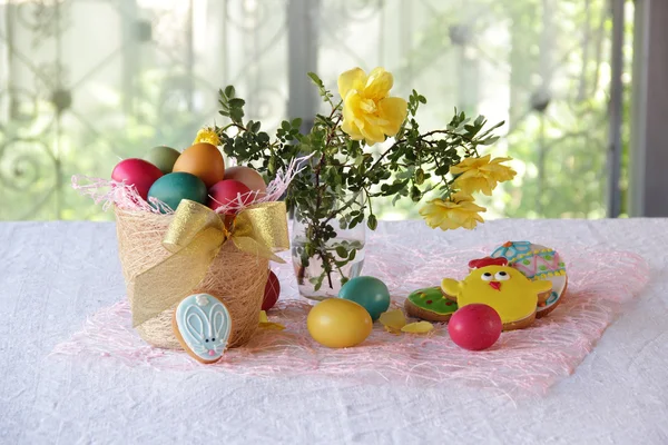 Bemalte Eier, Kekse und ein Strauß Rosen — Stockfoto