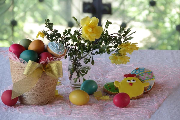 Malovaná vajíčka, sušenky a kyticí růží — Stock fotografie
