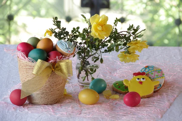 Uova dipinte, biscotti e un mazzo di rose — Foto Stock