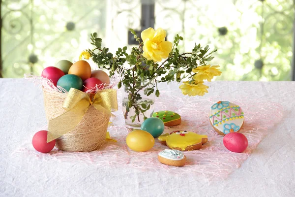 Huevos pintados, galletas y un ramo de rosas — Foto de Stock