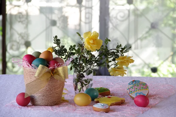 Пофарбовані яйця, печиво і букет троянд — стокове фото