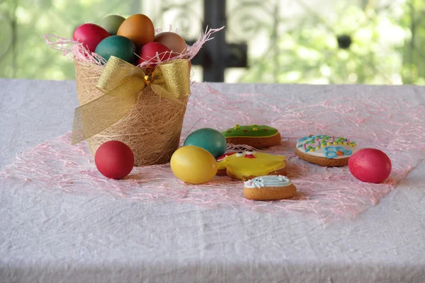 Ovos de Páscoa em cesta e biscoitos em forma — Fotografia de Stock