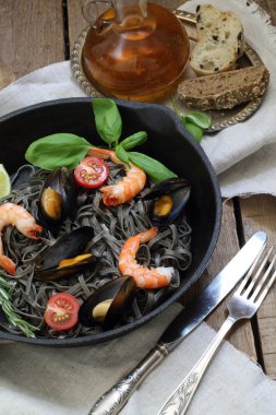 Siyah spagetti midye, karides, sarımsak, domates, fesleğen ve