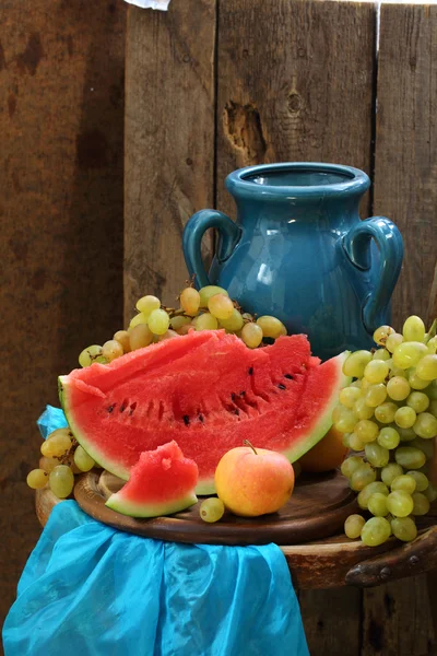 Натюрморт з блакитним глечиком, кавуном і виноградом — стокове фото
