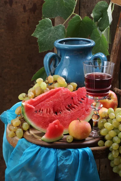 Stillleben mit Rotwein, Wassermelone und Trauben — Stockfoto