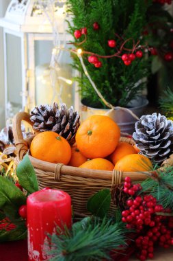 Mandalinalar sepetinde gümüş koniler ve yeni yıl dekoruyla