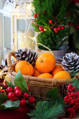 Mandalinalar sepetinde gümüş koniler ve yeni yıl dekoruyla