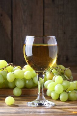 Tahta bir masada üzümlü beyaz şarap.