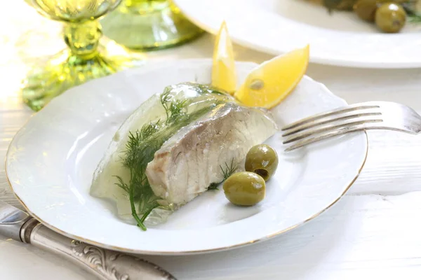 Jellied sturgeon with lemon, olives and glasses of white wine