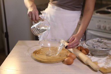 Kız bir kaseye su dolduruyor.