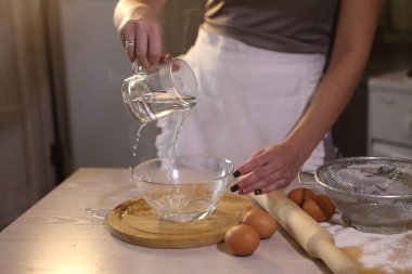 Kız bir kaseye su dolduruyor.