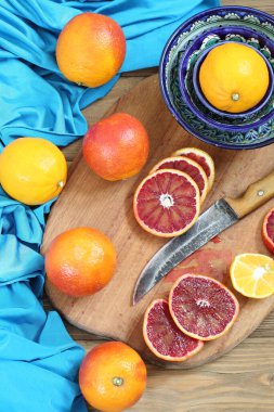 Tahta masada kırmızı portakallar ve limonlar