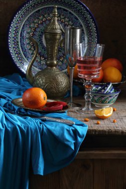 Ahşap arka planda kırmızı şarap ve portakallarla doğulu natürmort