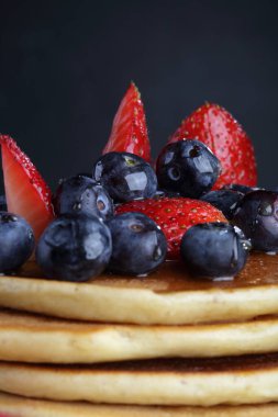Pancakes for breakfast. Pancakes with blueberries, strawberries, honey.