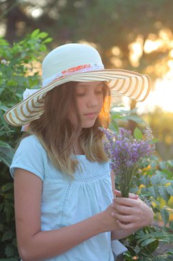 Bir buket lavantalı şapkalı kız.