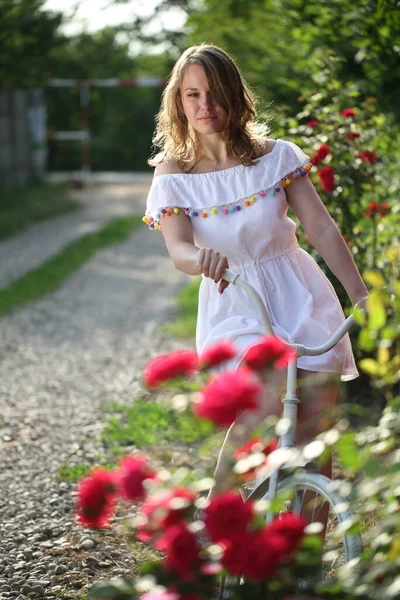 Красива Дівчина Білим Велосипедом Біля Куща Троянд — стокове фото