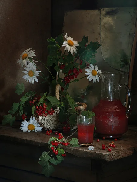 Berry juice from a red currant in a transparent jug and a bouque — Stock Photo, Image