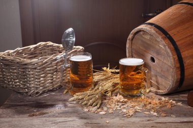 Bira köpük şeffaf bir kupa, ahşap bir popo ve koniler