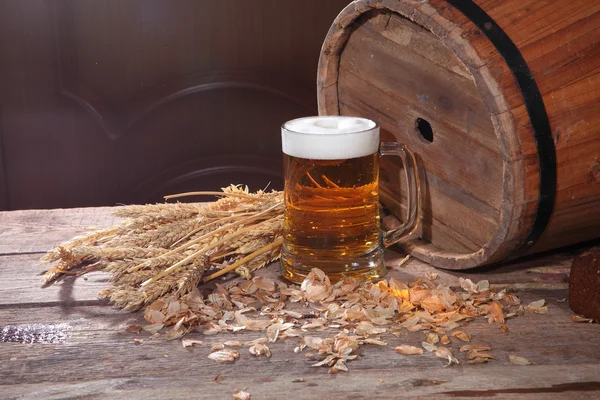 Cerveja com espuma em uma caneca transparente — Fotografia de Stock