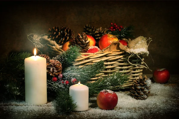 Apples and cones in a basket, candles and fur-tree branches in s — Stock Photo, Image